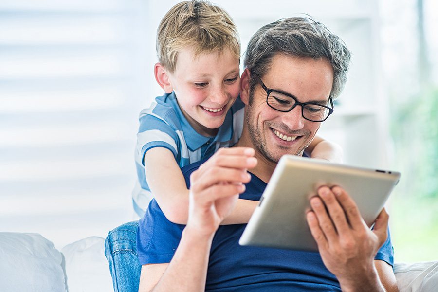 Client Center - A Father and His Young Son Are Having Fun Using a Tablet Together